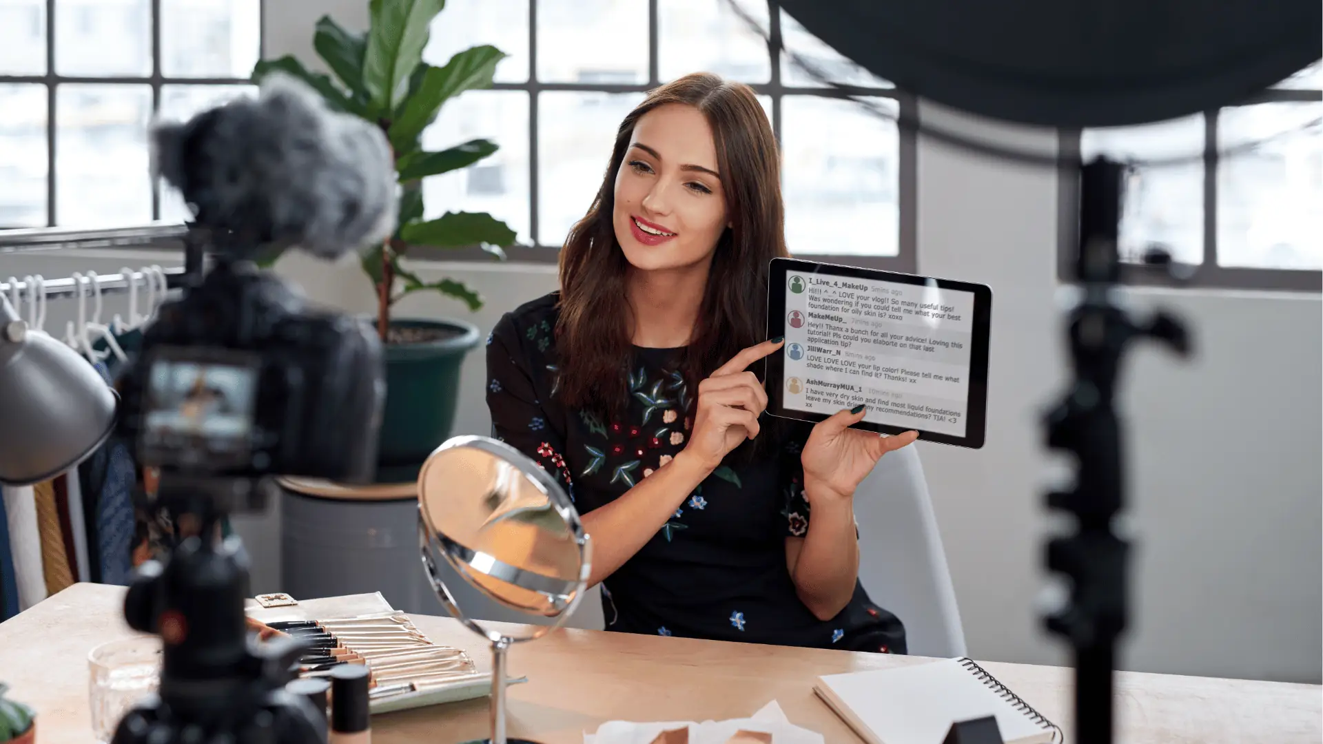Woman vlogger holding tablet and demonstrating makeup in a home studio