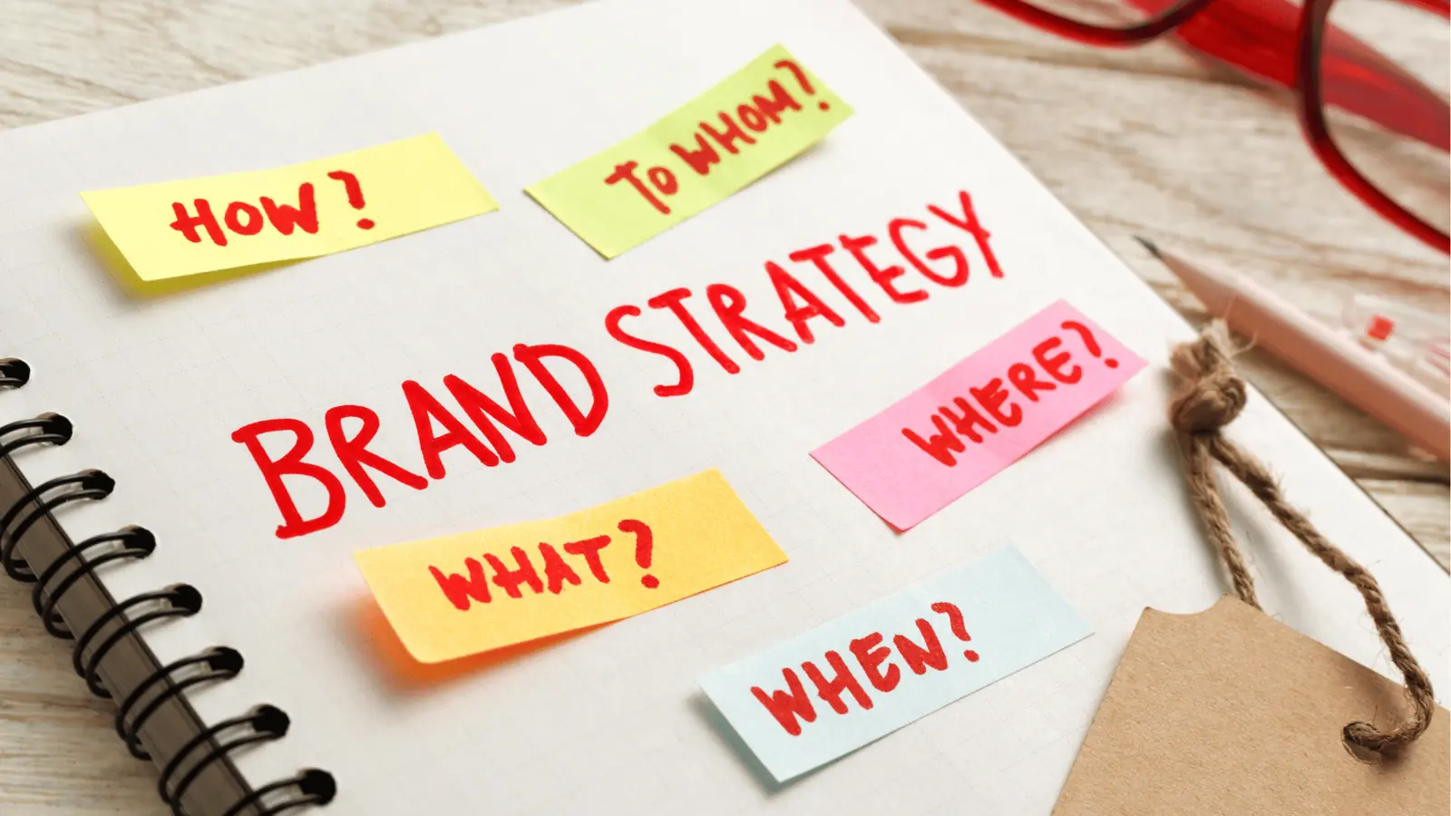 Notebook page with 'Brand Strategy' headline and colorful sticky notes for content calendar