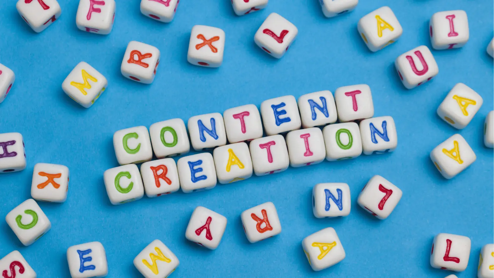 White cube letter beads arranged to spell CONTENT CREATION on blue background