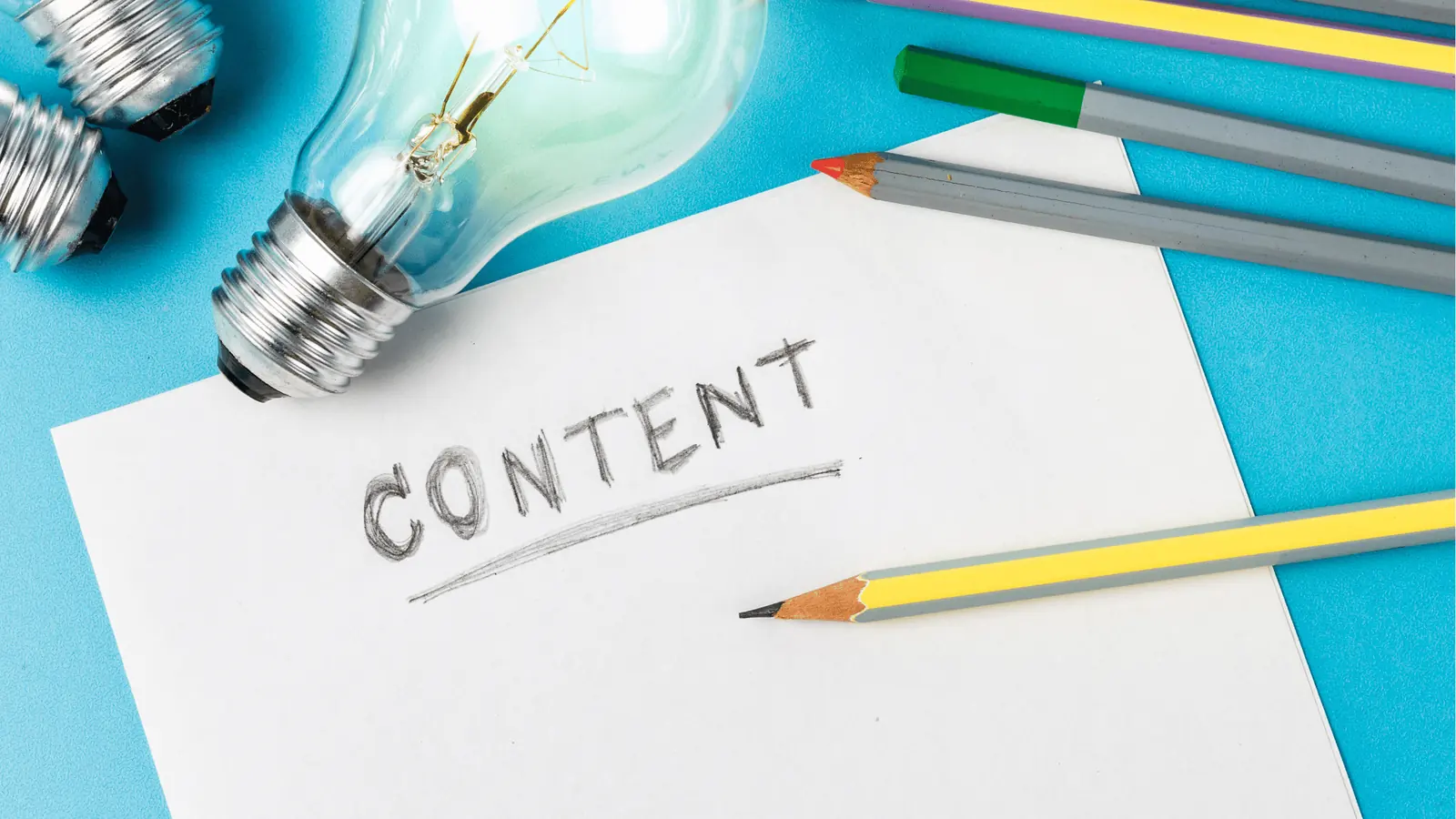Blank paper with the word CONTENT written and pencils beside light bulbs