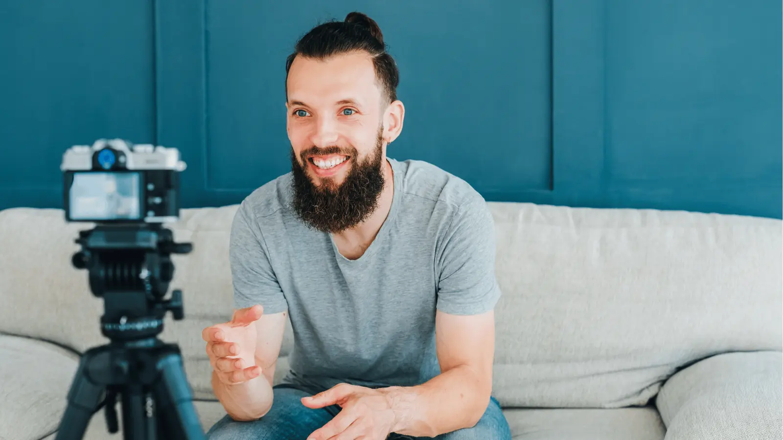 Bearded man sitting on sofa talking to camera mounted on a tripod