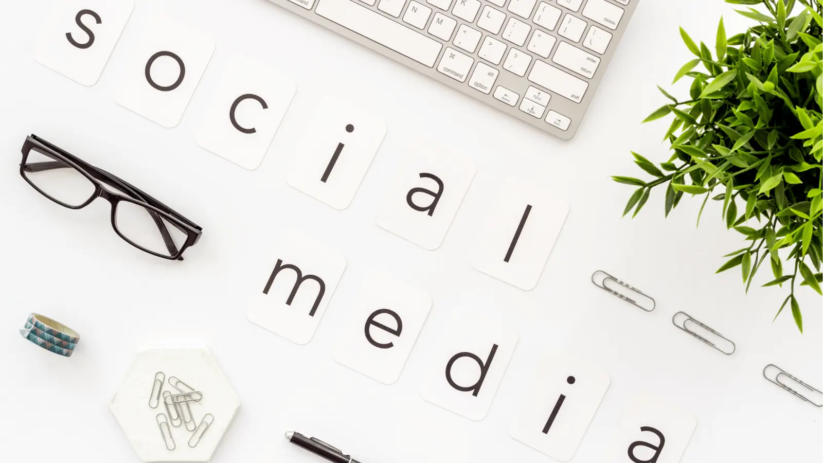 Flat lay desk with letter cards spelling social media and office items