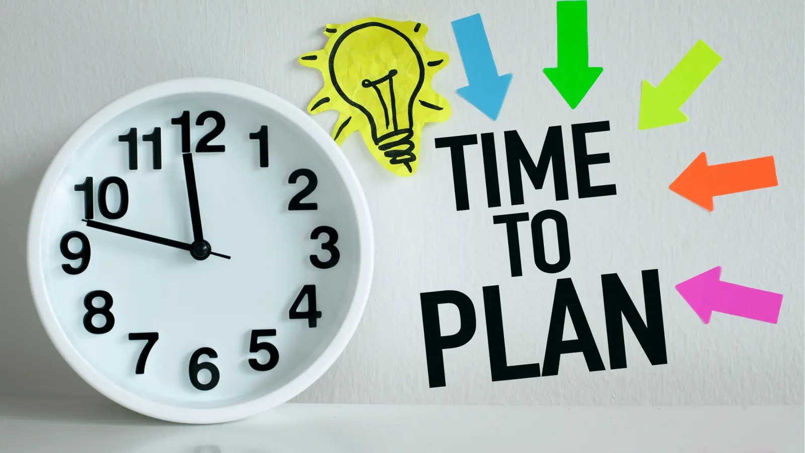 White wall clock beside text reading 'Time to Plan' with colorful arrow stickers