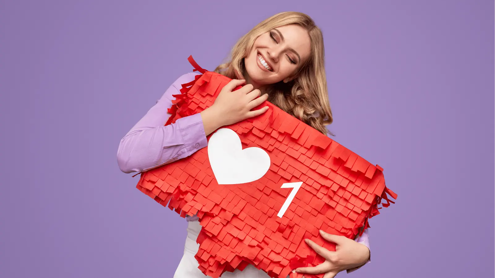 Smiling woman hugging a large red heart prop with white like icon