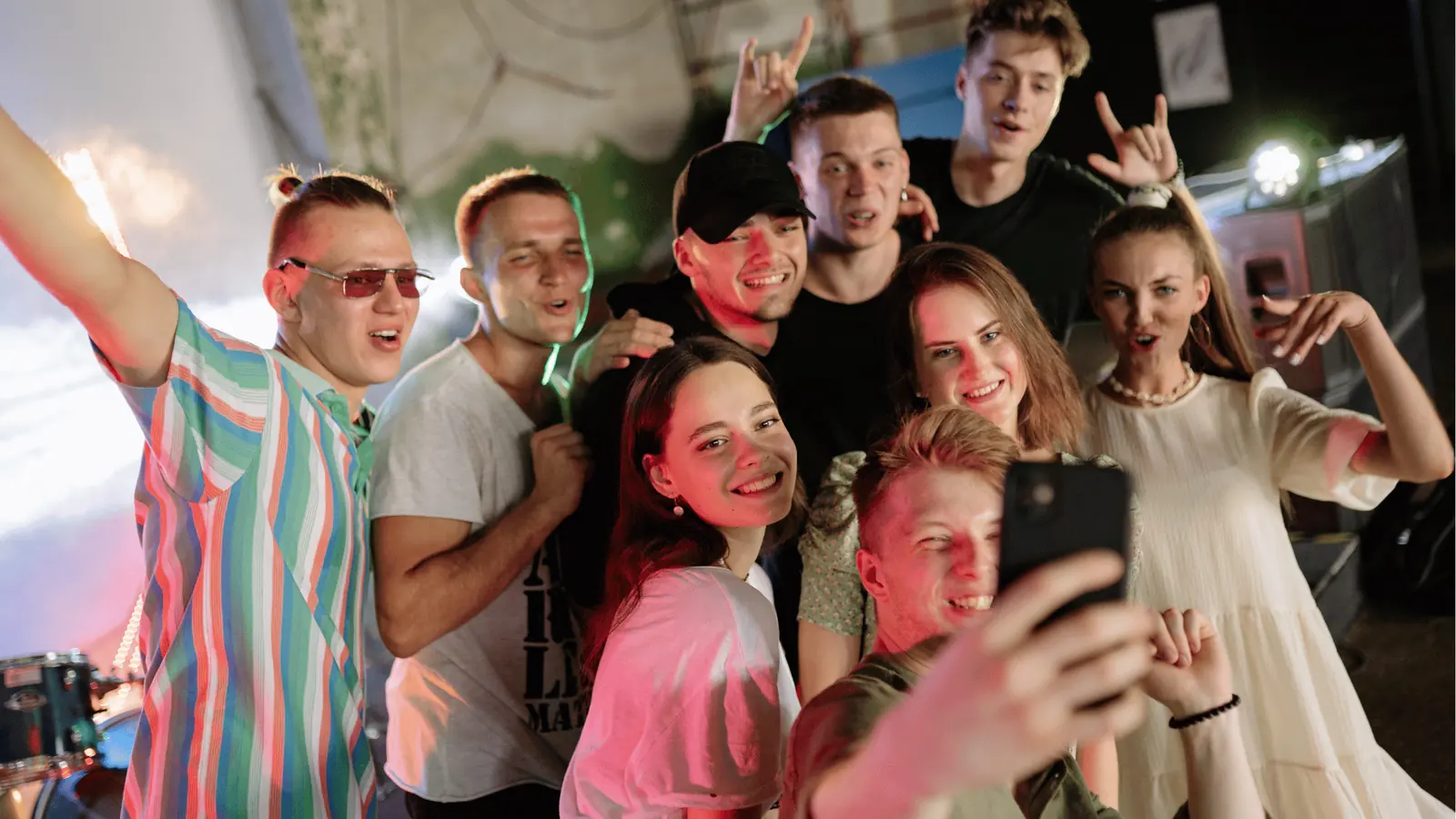 Group of young adults smiling and posing for a selfie at a party for content calendar